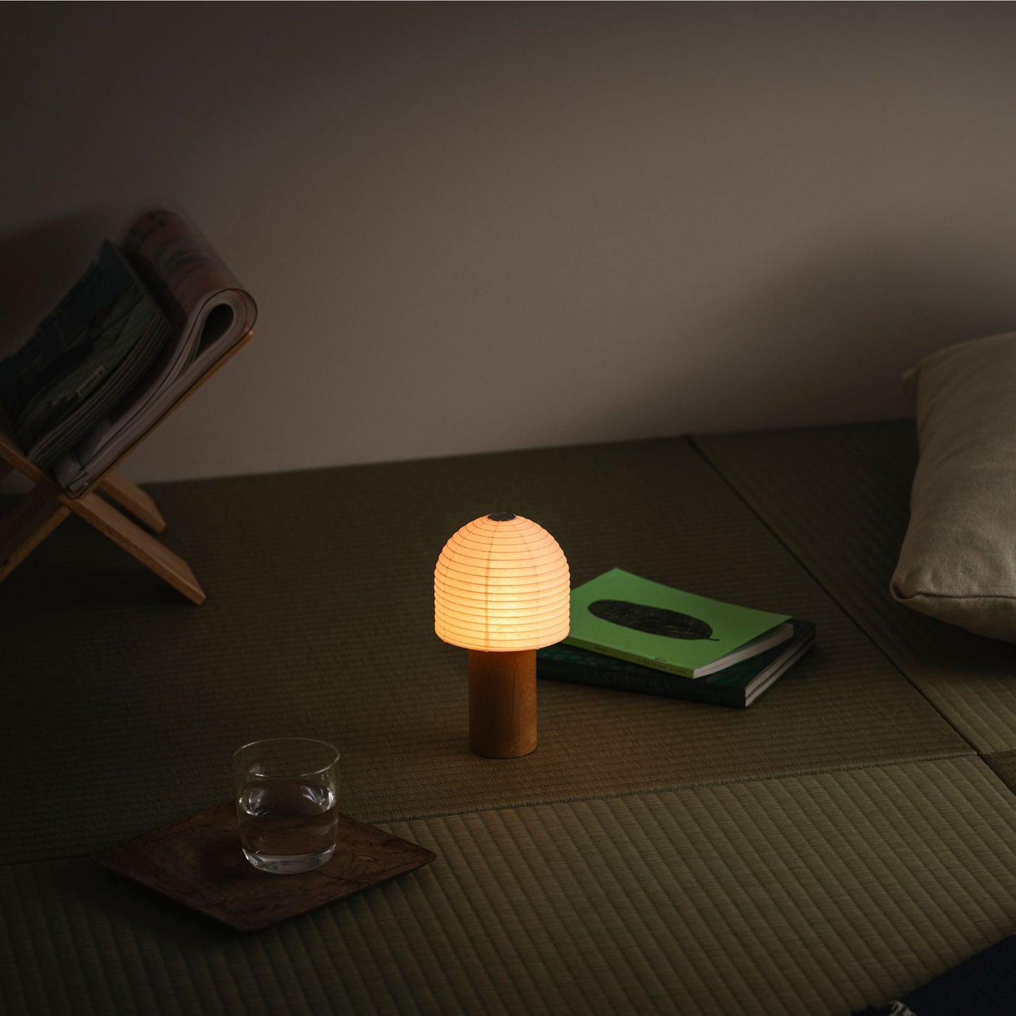 A portable Yame lantern glowing warmly, placed on a traditional tatami mat in a Japanese-style room