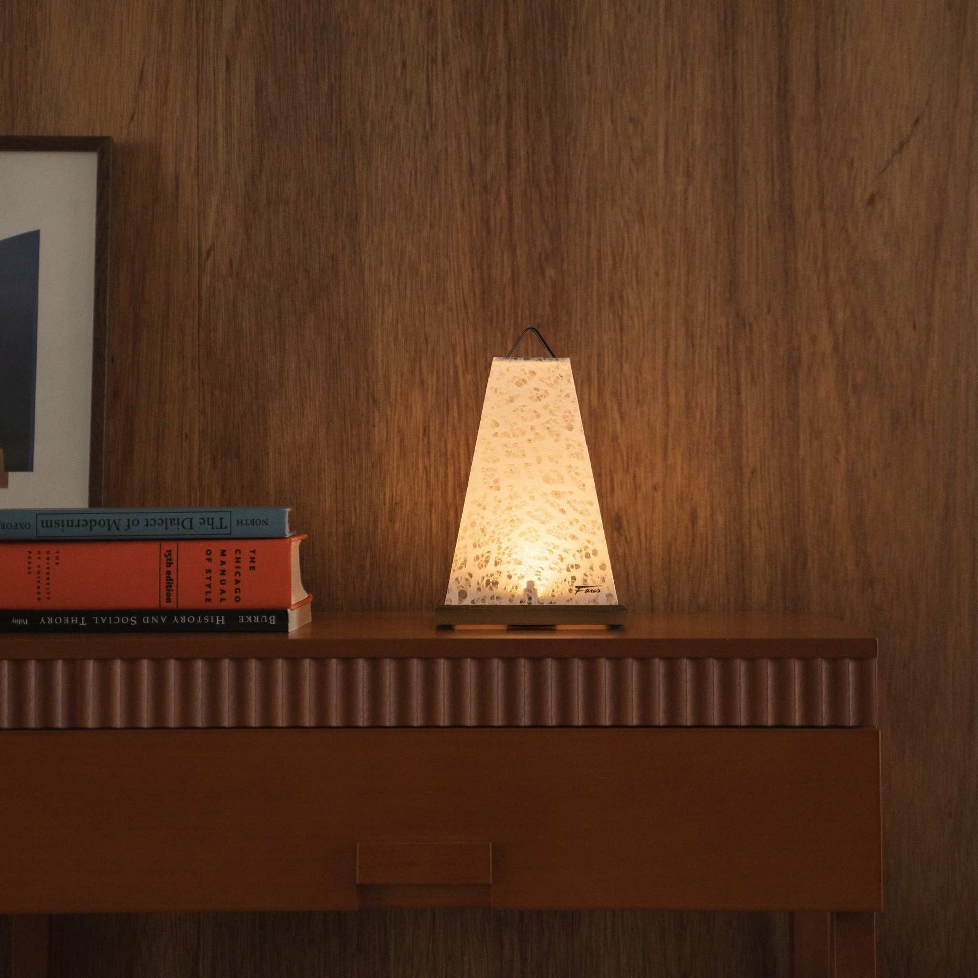 Lit Japanese paper table lamp "Mini Akari" White acting as a soft ambient lamp on a mid-century modern console table.