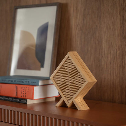 "Gros plan d'une lampe de table japonaise en bois « Kanata » posée comme une élégante décoration wabi sabi sur une console de style modern mid-century."