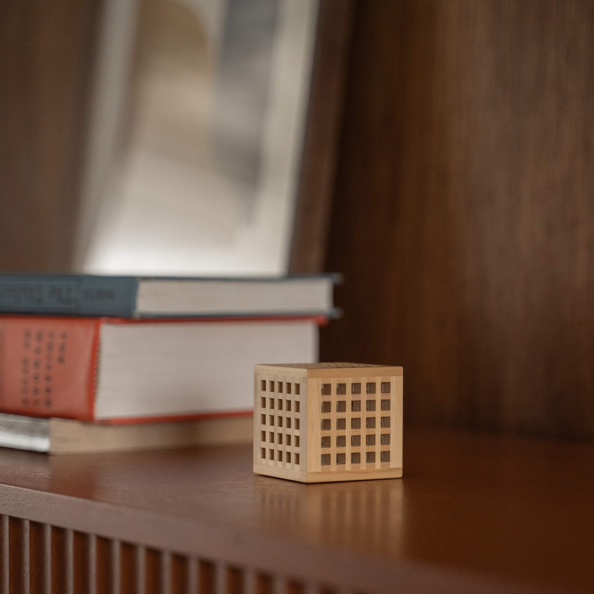"Lampe japonaise miniature en bois non allumée « Hotaru » présentant un travail détaillé du bois Kumiko comme lampe de table japonaise sur une étagère en bois."