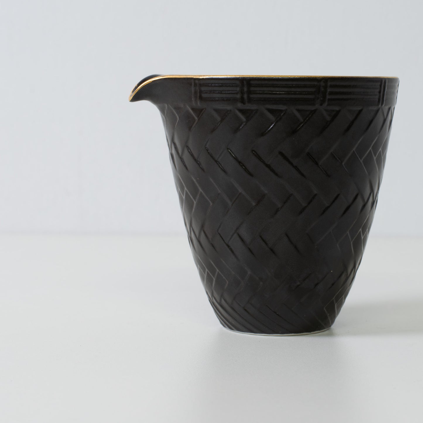 Basket weave sake carafe, black porcelain - Close up of a Japanese sake carafe highlighting the woven texture