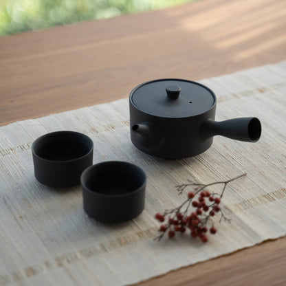 Service à thé japonais noir « Sencha » avec une large kyusu sur une table ensoleillée pour minimalistes préparant un rituel bien-être quotidien épuré.