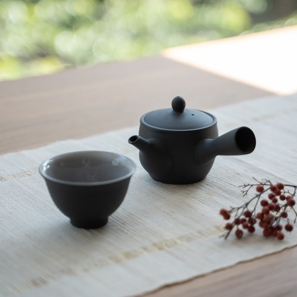 Black Japanese teapot "Fuyo" and Japanese tea cup on a table for tea enthusiasts preparing an intimate mindful tea ritual.