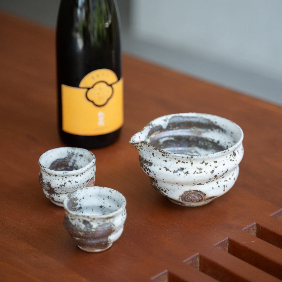 Zui ungleichmäßiges weißes japanisches Sake-Set, Karaffe und Becher auf einem Esstisch, um besonderen Abendessen mit Gästen Eleganz zu verleihen