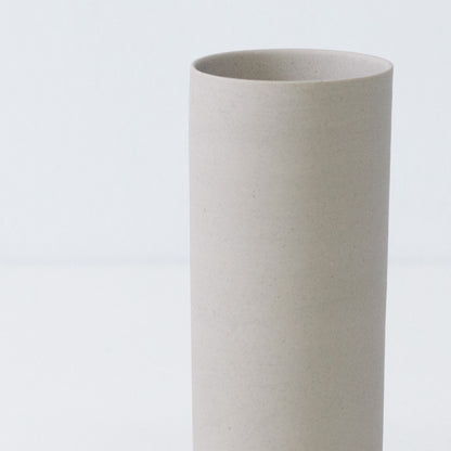 Detailed view of a matte white Japanese flower vase featuring natural iron spots and artisan trowel marks.