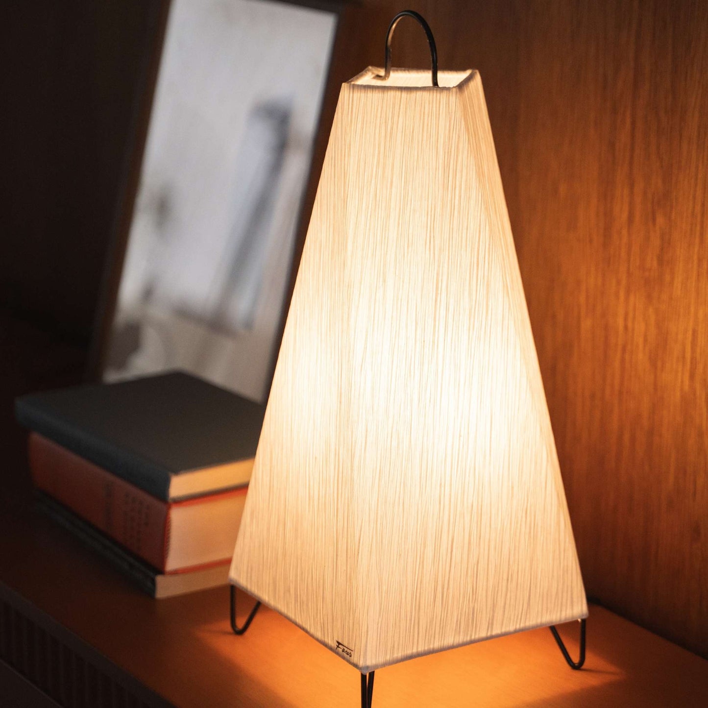 Close-up of a lit Japanese paper floor lamp ORI small on a console table, highlighting its unique wrinkled paper texture.