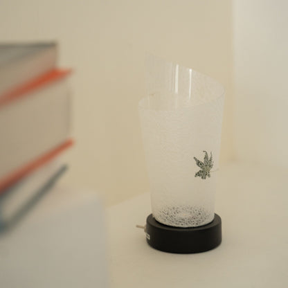 Close-up of an unlit Japanese paper table lamp "Maki" Momiji Leaf showcasing its rolled design and natural paper texture for wabi sabi decor.