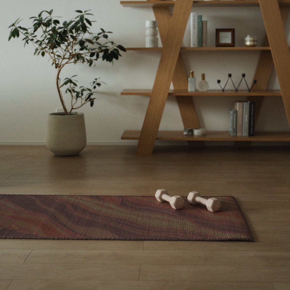 Japanese Tatami Yoga Mattress "Marble" Pink with dumbbells on a wooden floor in a stylish Japandi room for daily practice.