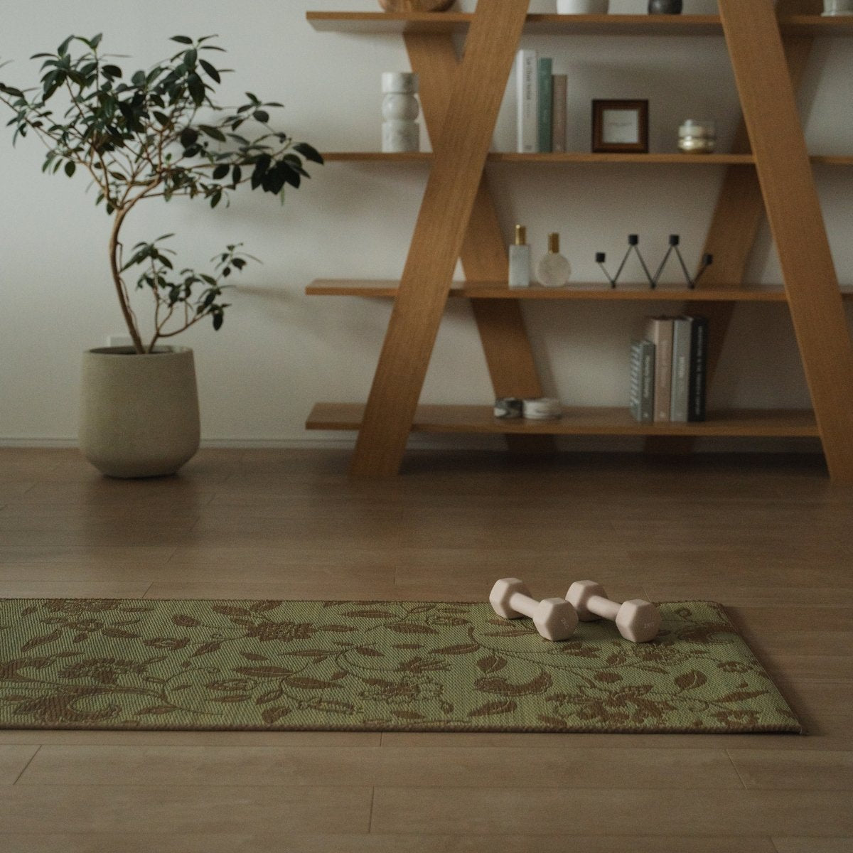 Japanse Tatami Yogamat "Sarasa" Beige met modern botanisch patroon op een houten vloer in een rustige Japandi mindful hoek.