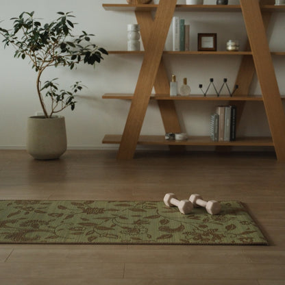 Japanse Tatami Yogamat "Sarasa" Beige met modern botanisch patroon op een houten vloer in een rustige Japandi mindful hoek.