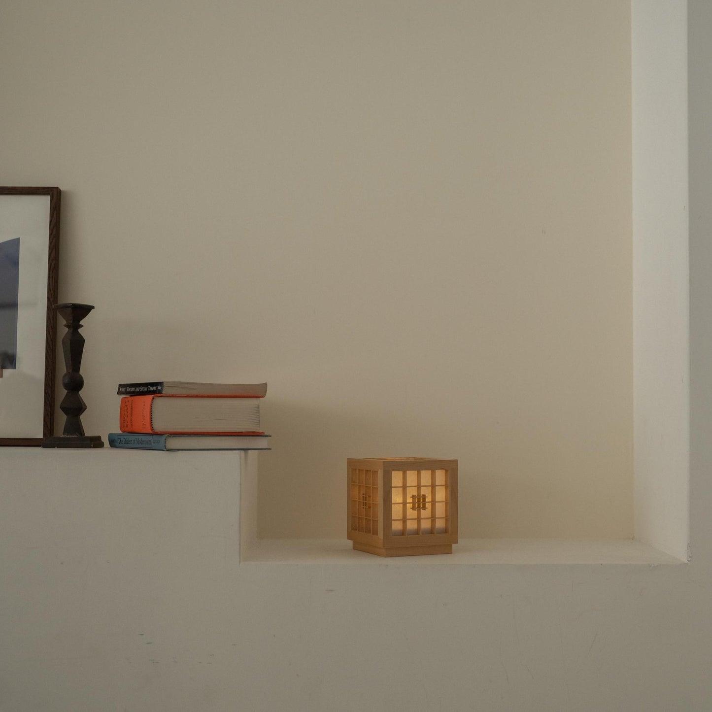 "Lampe de table japonaise en bois « Honoka » allumée sur une console blanche, servant de lampe d'ambiance chaleureuse pour la détente."