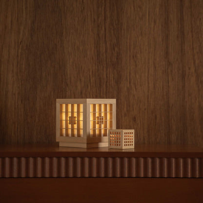 "Lampe de table japonaise en bois « Honoka » et « Hotaru » illuminant comme des lampes d'ambiance sur une console de style mid-century modern."