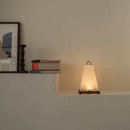 Lit Japanese paper table lamp "Mini Akari" White casting a warm glow as an accent lamp on a white Japandi living room console.