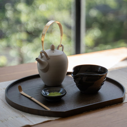 Sumi Black Spouted Japanese Matcha Bowl and Teapot, on a wooden tray by a sunlit window, ready for a modern matcha latte ritual.
