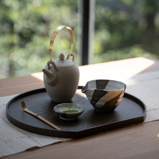 White Flow Japanese matcha bowl with spout and teapot on a wooden tray by a window, for an authentic matcha latte routine