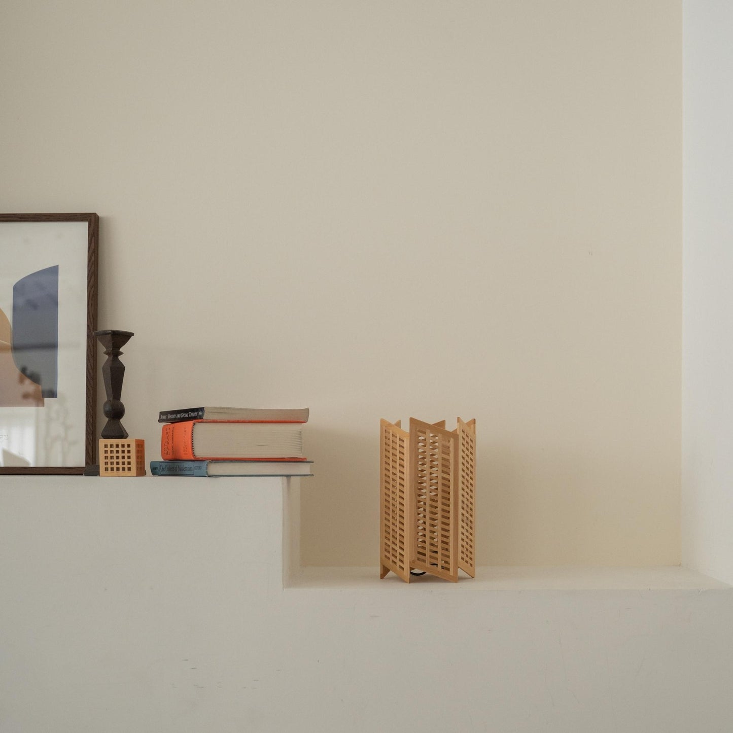 Lampe de table japonaise "Towaru" en bois non allumée, disposée sur une console blanche, mettant en valeur un design minimaliste Japandi.