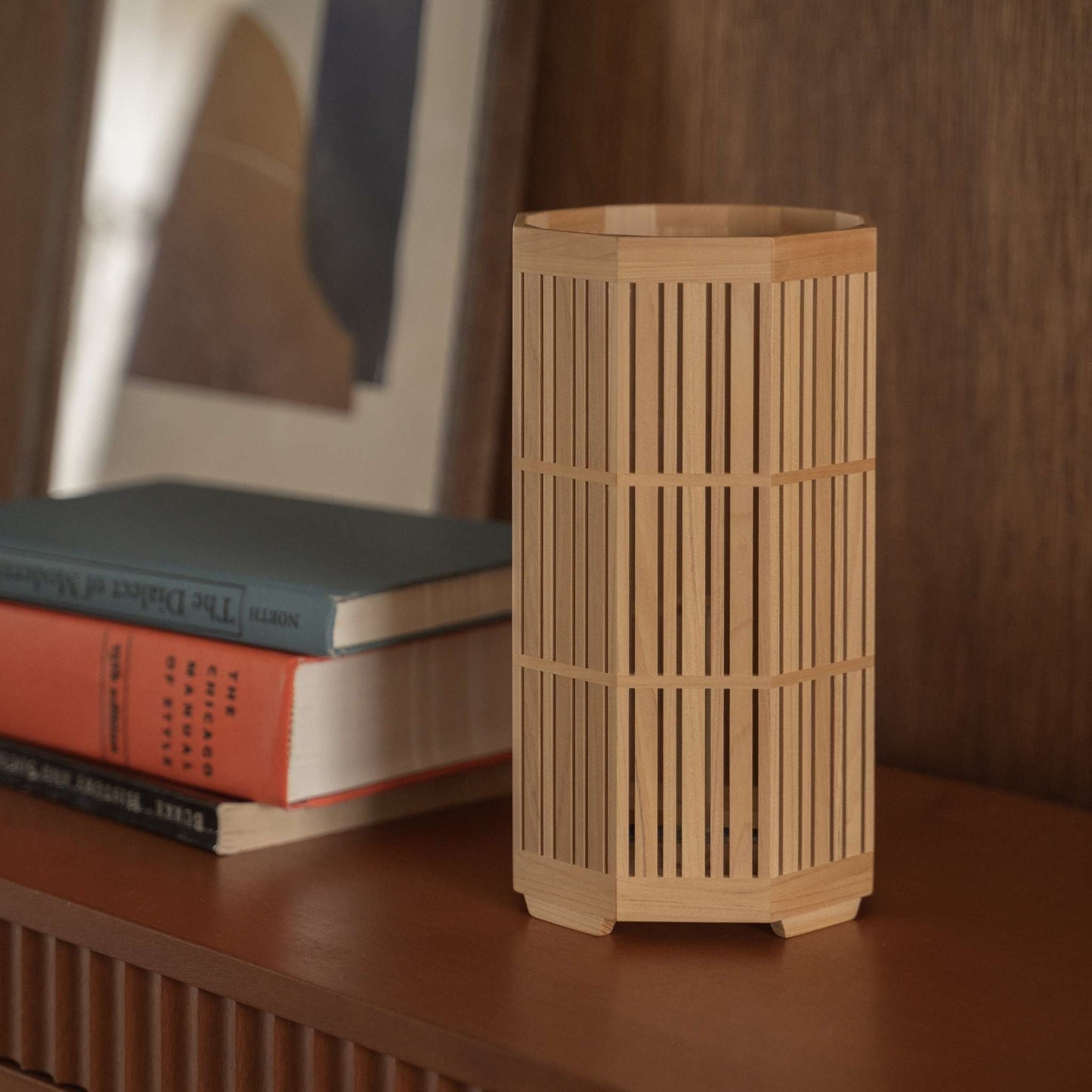 "Gros plan d'une lampe de table japonaise en bois « Kagayaki » posée comme décoration wabi sabi sur une console de style modern mid-century."