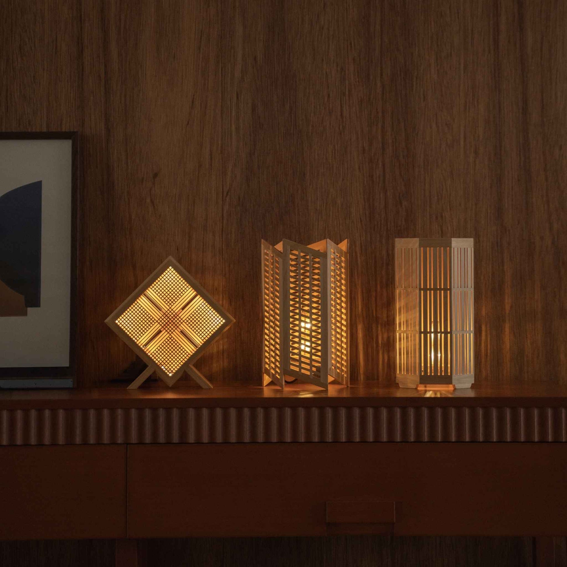 Lit Japanese table lamp "Kanata", "Towaru", and "Kagayaki" glowing as ambient lamps on a mid-century modern console table.