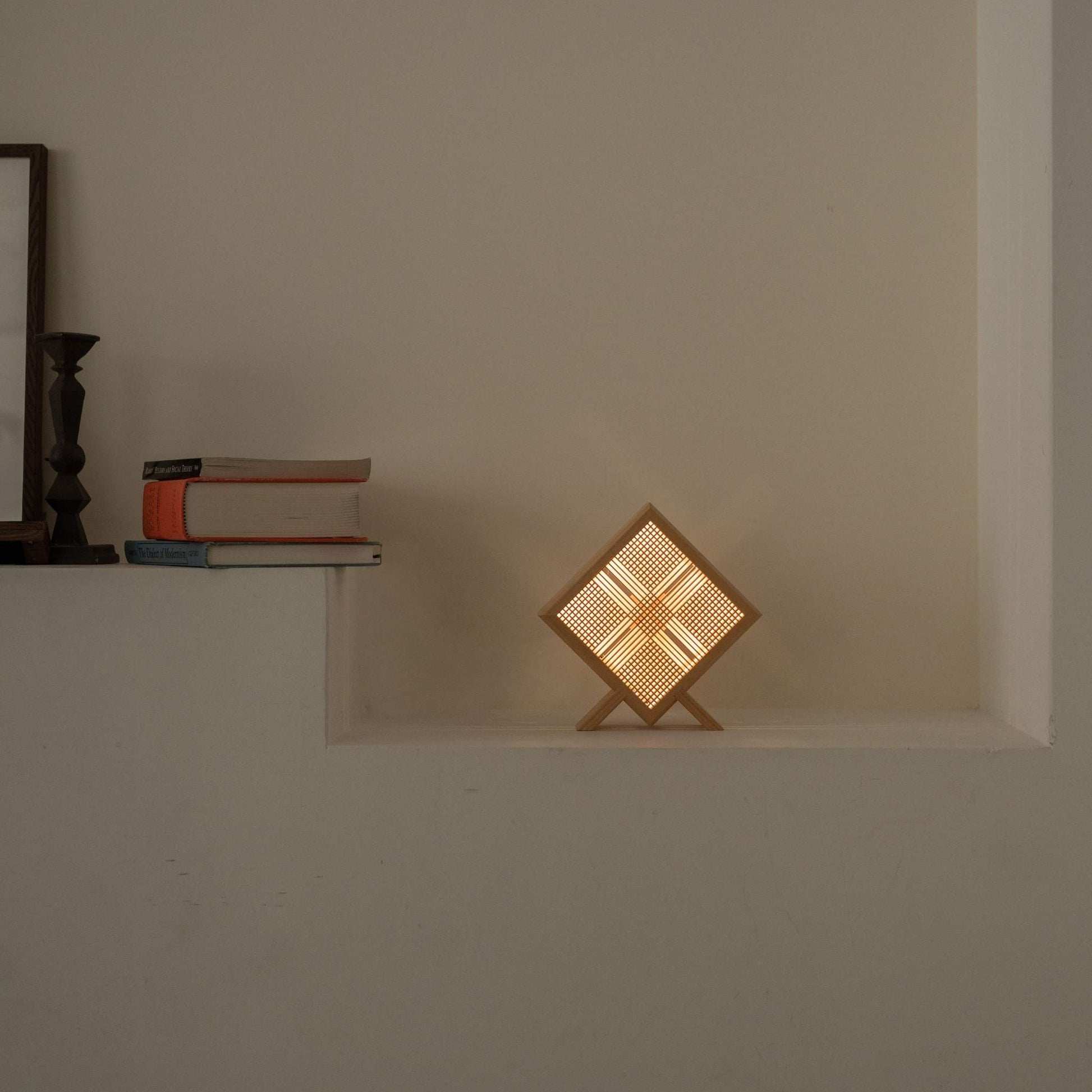 Lampe de table japonaise en bois "Kanata" lumineuse servant de lampe d'ambiance sur une console blanche dans un salon Japandi.