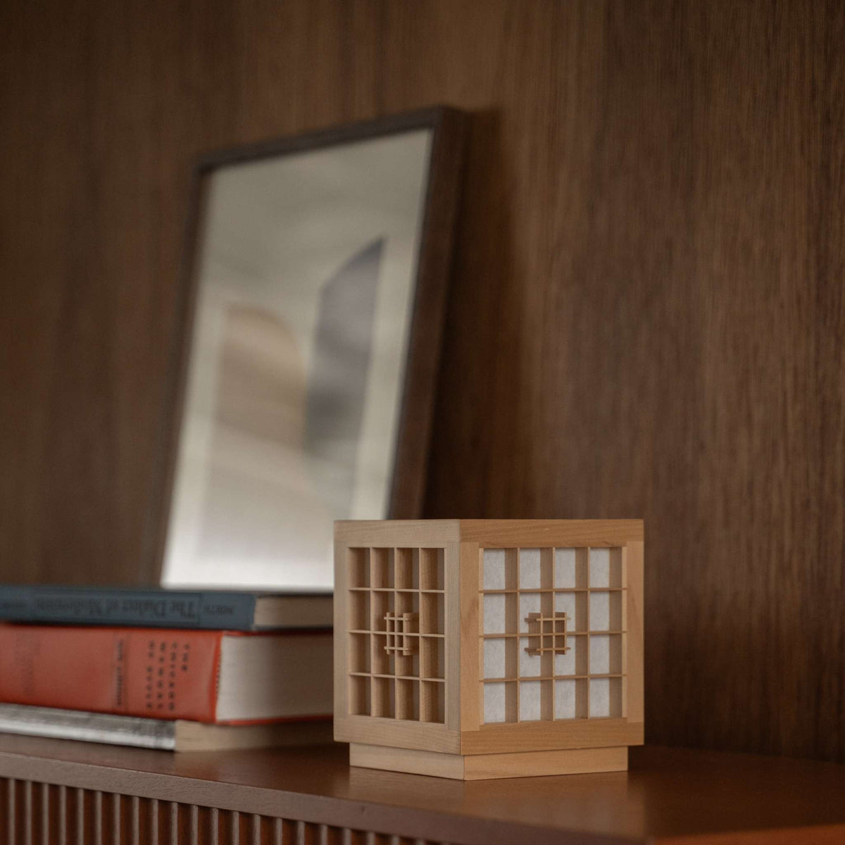 Japanese Wood Table Lamp "Honoka" used as a handcrafted wabi sabi accent lamp on a wooden shelf in a mid-century-modern room.