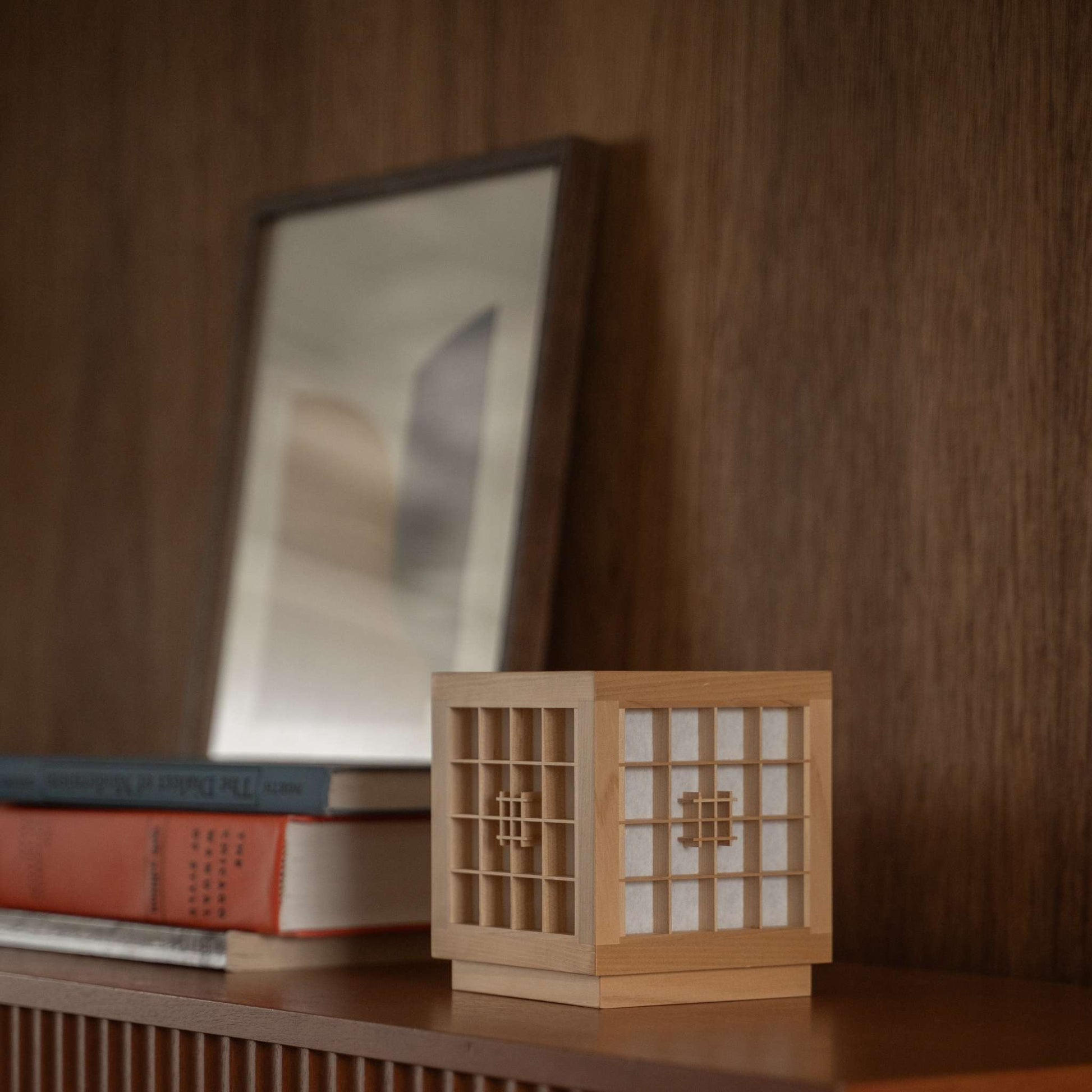 "Lampe de table japonaise en bois « Honoka » utilisée comme lampe d'appoint artisanale de style wabi sabi sur une étagère en bois dans une pièce de style mid-century modern."
