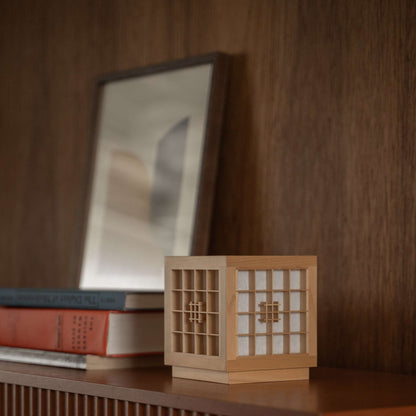 "Lampe de table japonaise en bois « Honoka » utilisée comme lampe d'appoint artisanale de style wabi sabi sur une étagère en bois dans une pièce de style mid-century modern."