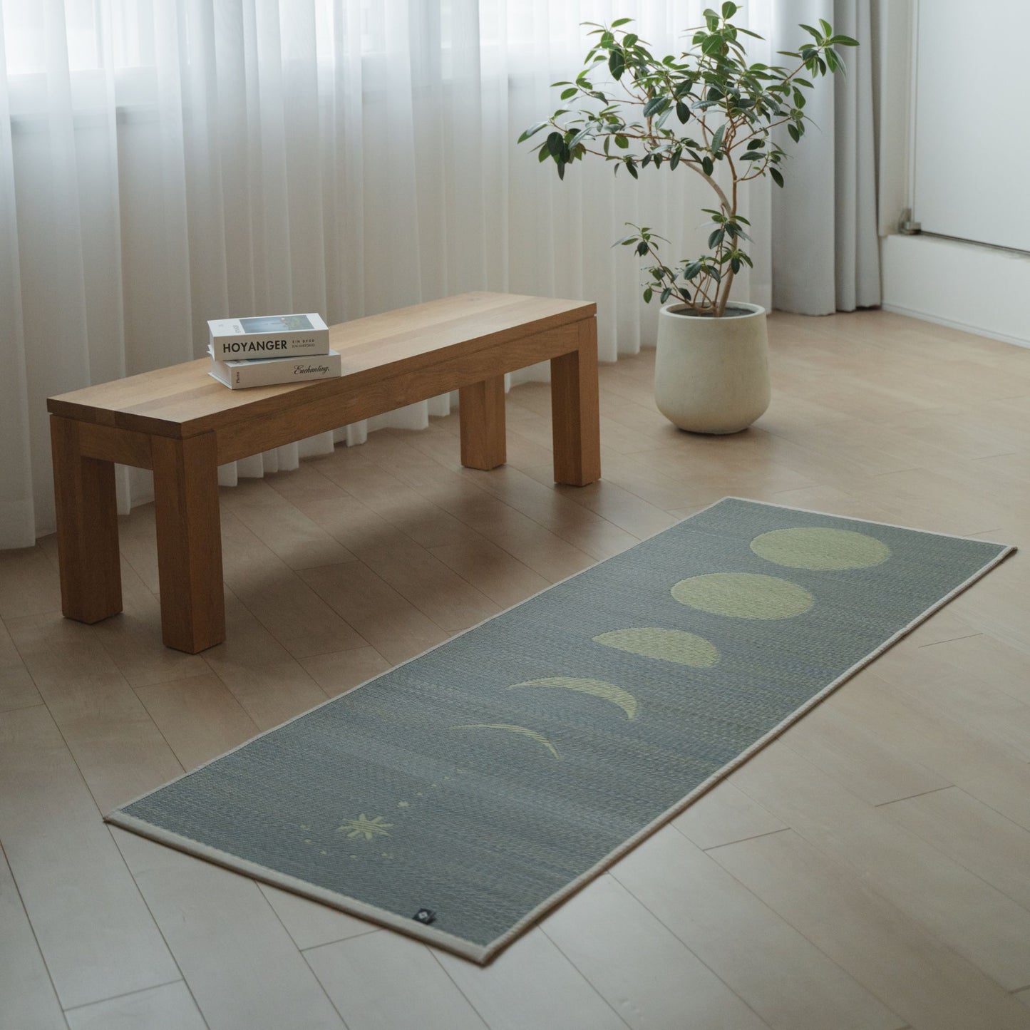 Japansk Tatami-yogamåtte "Moon" i grå, placeret på et moderne trægulv i en minimalistisk stue for at skabe et naturligt og beroligende rum til hjemmetræning.