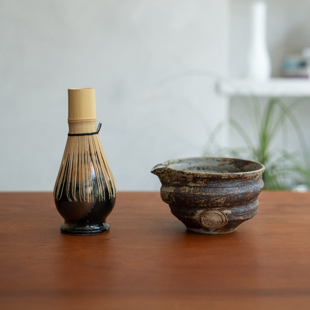 Dark Sakigake spouted matcha bowl and Zen Japanese matcha whisk stand on a table, to elevate your morning matcha ritual
