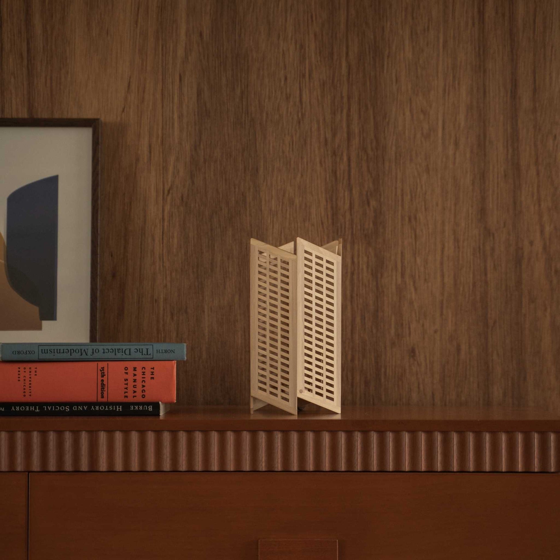 Lampe de table japonaise non allumée en bois "Towaru" se dressant comme une élégante décoration wabi sabi sur une console en bois de style mid-century modern.