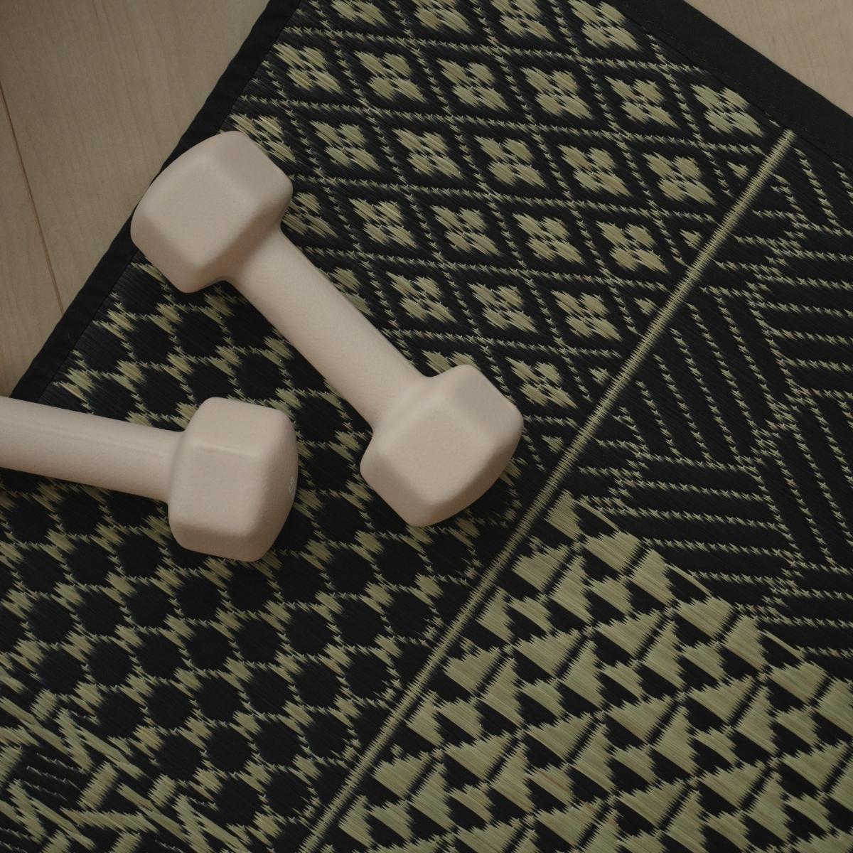 Overhead view of the Japanese Tatami Yoga Mattress "Ed Plain" Black with dumbbells for a stylish home yoga setup.