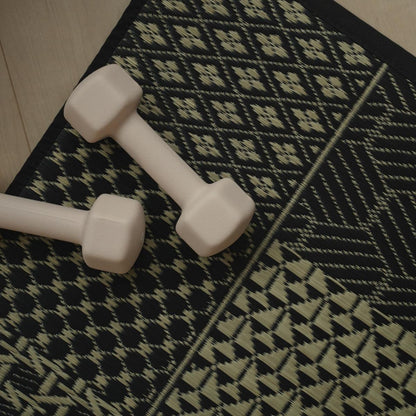 Overhead view of the Japanese Tatami Yoga Mattress "Ed Plain" Black with dumbbells for a stylish home yoga setup.
