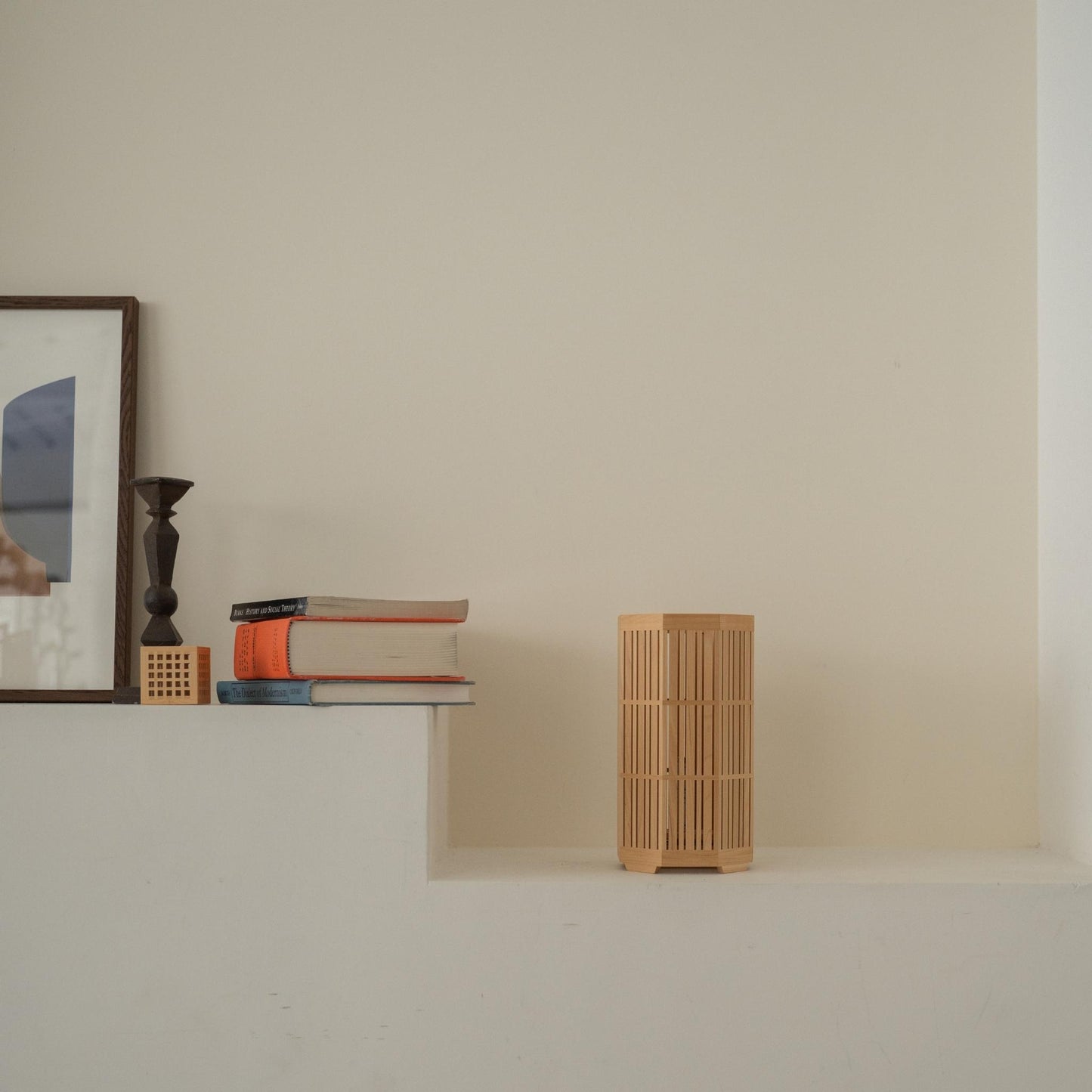 "Lampe de table japonaise en bois non allumée « Kagayaki » servant de décoration japonaise sur une console blanche de style Japandi."