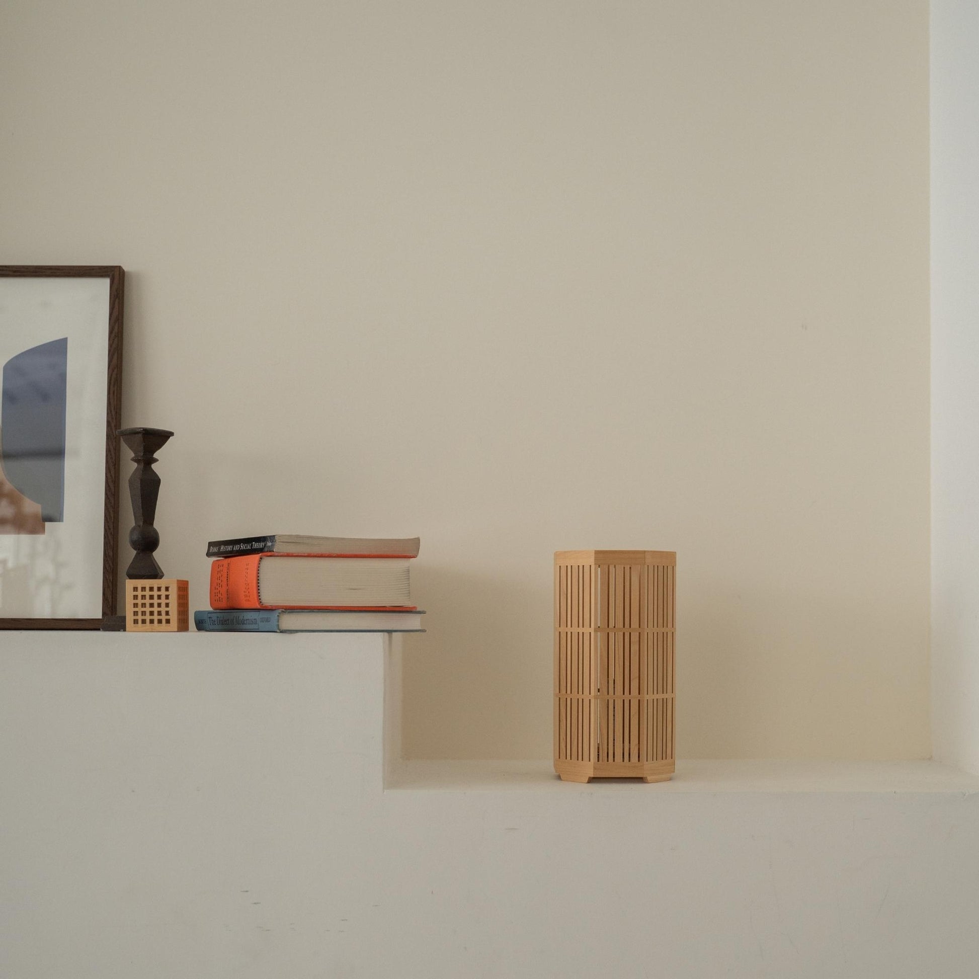 "Lampe de table japonaise en bois non allumée « Kagayaki » servant de décoration japonaise sur une console blanche de style Japandi."