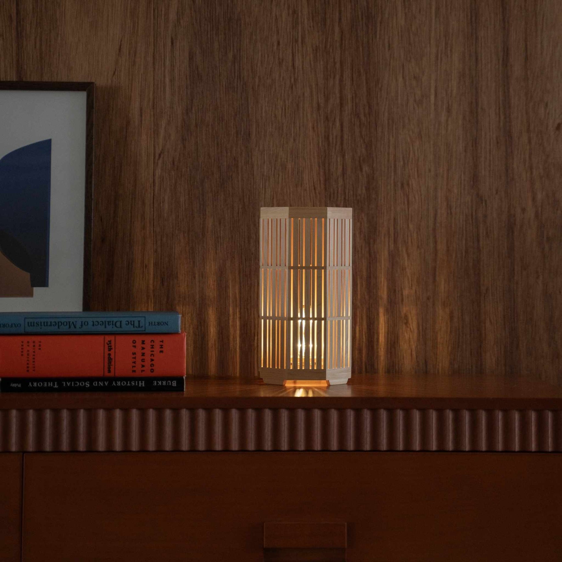 "Lampe de table japonaise en bois "Kagayaki" lumineuse servant de lampe d'appoint chaleureuse sur une console en bois dans un salon de style mid-century modern."