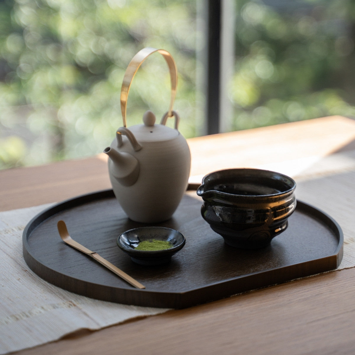 Dignity Blue matcha bowl with spout and teapot on a tray by a window, perfect for authentic whisking or casual lattes