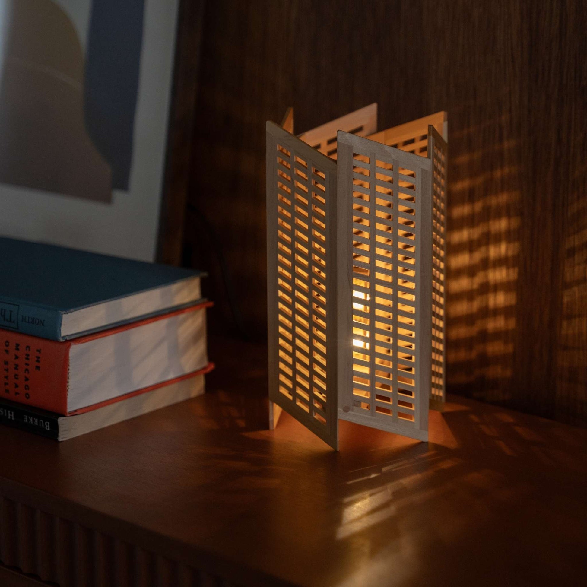 "Lampe de table japonaise en bois "Towaru" sur un meuble-console de style modern mid-century, projetant des ombres linéaires saisissantes en tant que lampe d'ambiance."