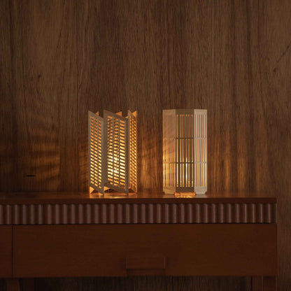 "Lampe de table japonaise en bois « Towaru » et « Kagayaki » projetant des ombres chaudes comme lampes d'ambiance sur une console moderniste du milieu du siècle."