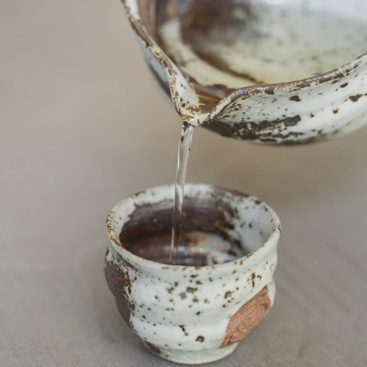 Zui japanisches Sake-Set mit Katakuchi-Karaffe und Bechern auf einem Tablett, für ein reifes Luxuserlebnis am Beistelltisch