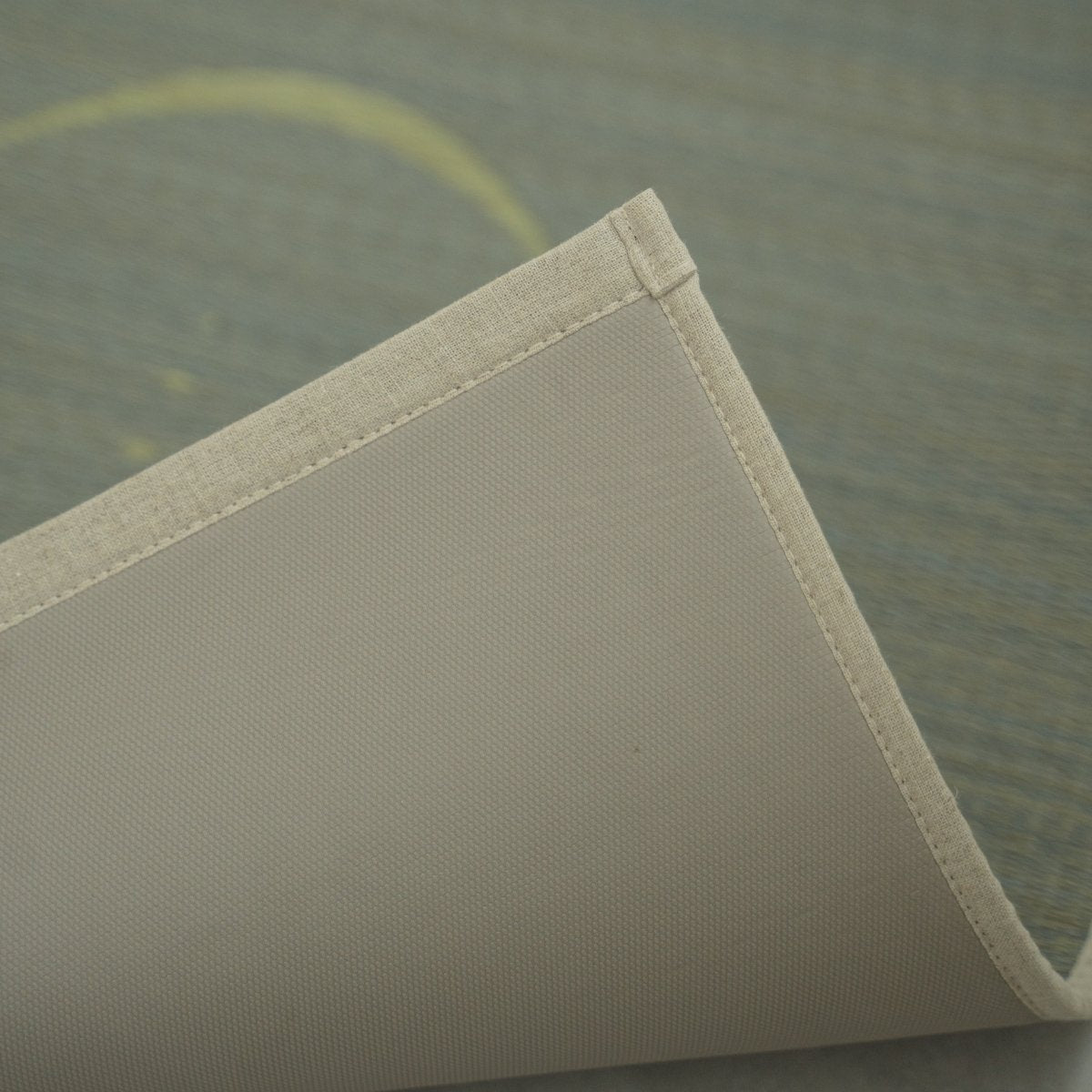 "Graue japanische Tatami-Yogamatte „Mond“, an der Ecke leicht angehoben, wodurch die sauberen Kanten und die rutschfeste TPE-Rückseite für sicheres Training sichtbar werden."