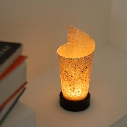 Glowing Japanese paper table lamp "Maki" Cedar Bark revealing rustic paper details and providing a soft glow as a cozy accent lamp.