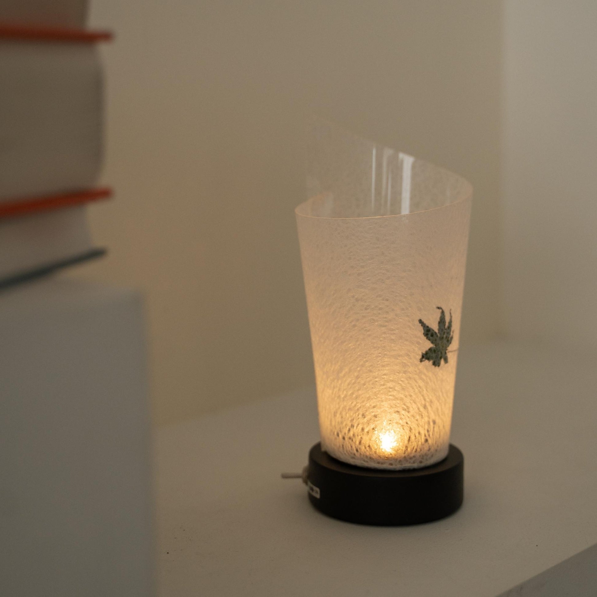 Glowing Japanese paper table lamp "Maki" Momiji Leaf revealing harusame washi paper details and providing a soft glow as a cozy accent lamp.