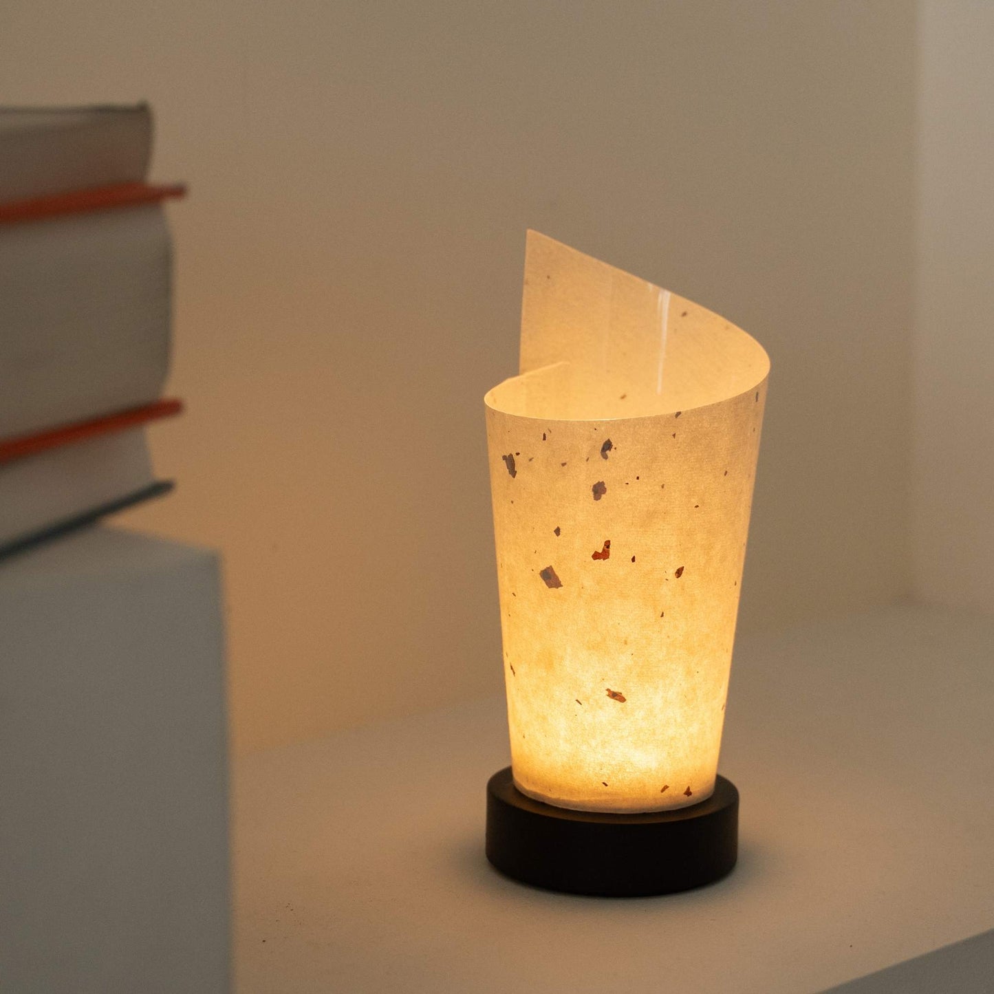 Glowing Japanese paper table lamp "Maki" revealing rustic paper details and providing a soft glow as a cozy accent lamp.