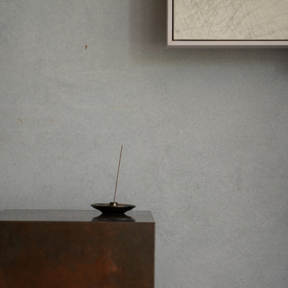 Gold and Black ceramic Japanese incense holder on a rich wooden console, creating a calming atmosphere for a daily yoga routine.