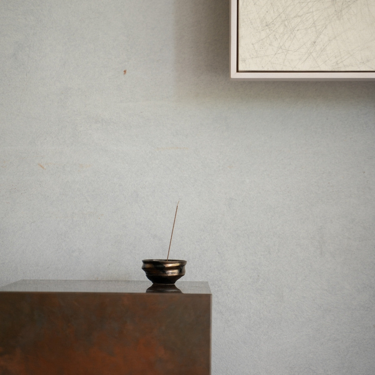 Gold and Black Japanese incense burner on a rustic wooden console, creating deep serenity for a daily yoga routine.