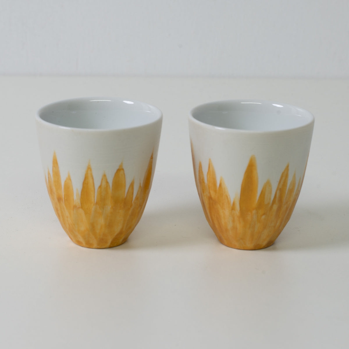 Gold floral sake cups, white porcelain - Two Japanese sake cups featuring a gold floral base design