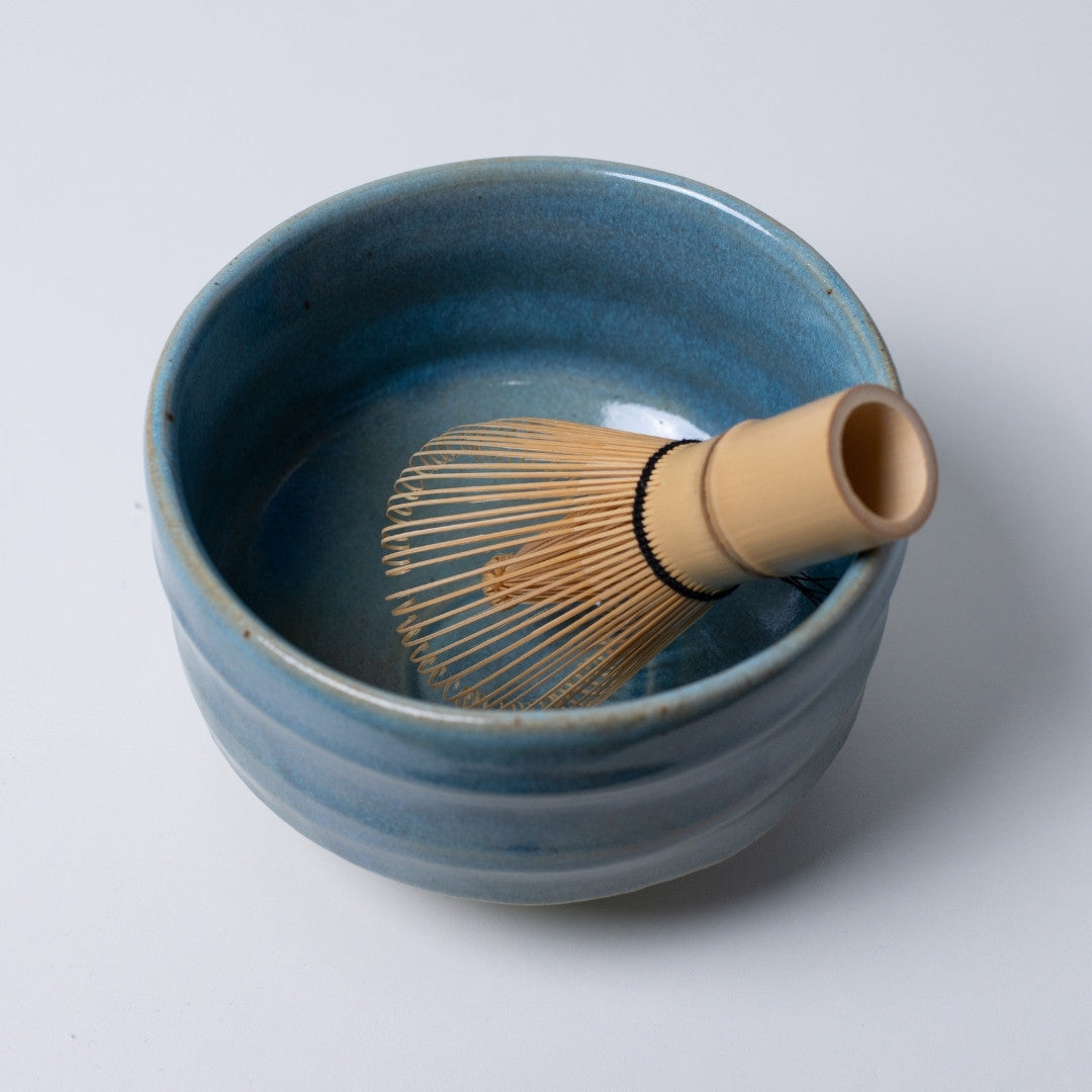 Top view of "Summer Sky" Japanese matcha bowl with a bamboo whisk, highlighting the refreshing blue interior for serene tea rituals.