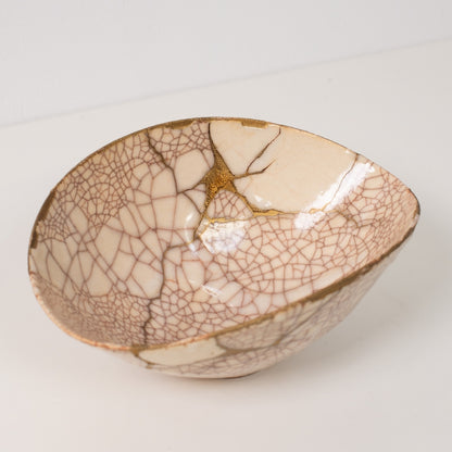 High angle view inside a white kintsugi bowl revealing the golden repairs that define wabi sabi resilience