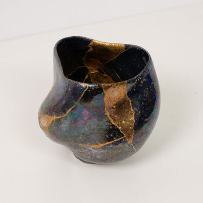 Close up looking inside an iridescent kintsugi matcha bowl displaying gold lines that celebrate traditional wabi sabi art