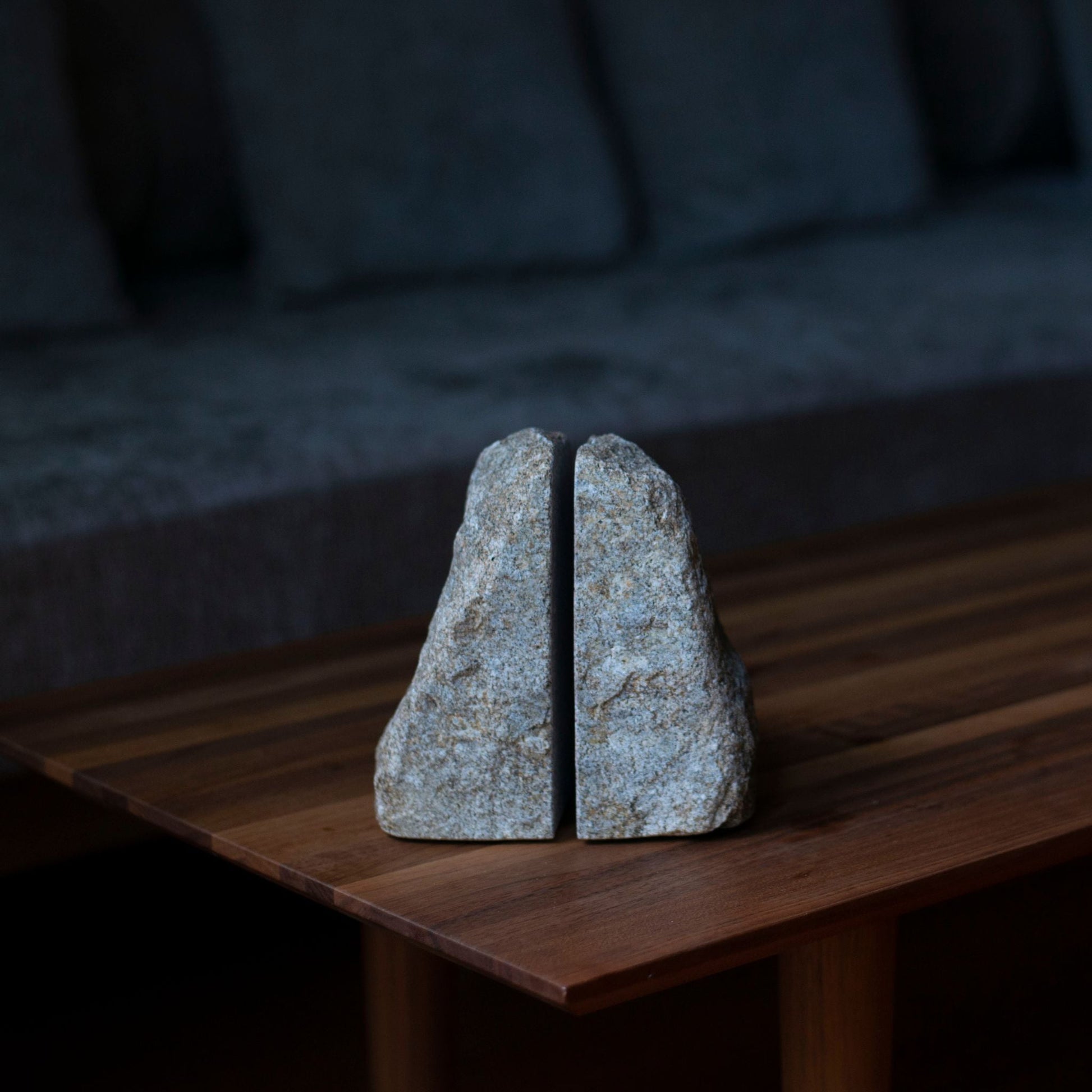 A Japanese Aji stone bookend placed on a natural wood table in a minimalist Japandi style living room.