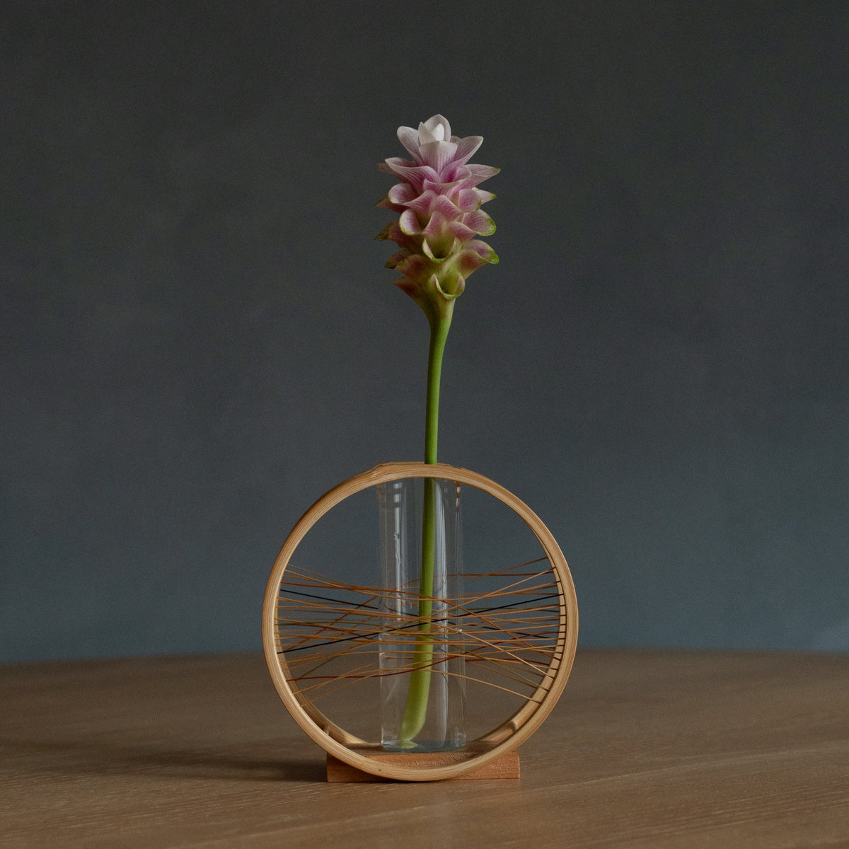 Japanse bamboe bloemenvaas "Flowing Wind" in bruin, gepresenteerd in een eetkamer, sfeerbeeld van een eettafel.